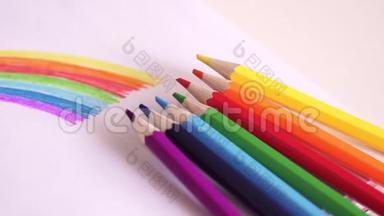 彩色铅笔躺在桌子上画彩虹。 色彩鲜艳的图画。 彩虹。